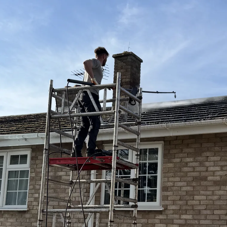 Cleaning the roof from a scaffold tower